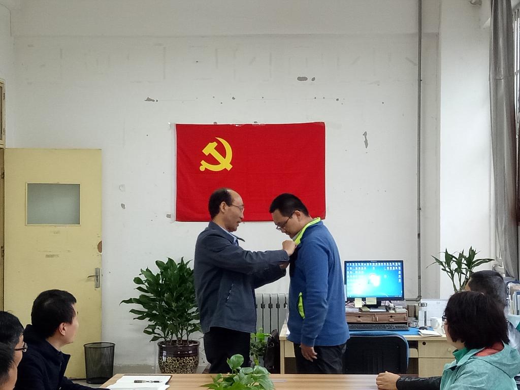 郝红武为员工党员代表佩戴党徽